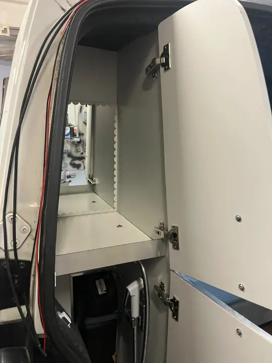 Szafka techniczna z instalacją elektryczną za tylnymi drzwiami