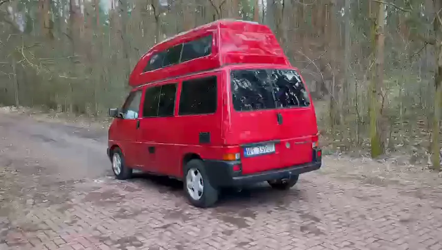Film: czerwony VW Transporter – kuchnia z drewnianym blatem i wysuwana szuflada w bagażniku