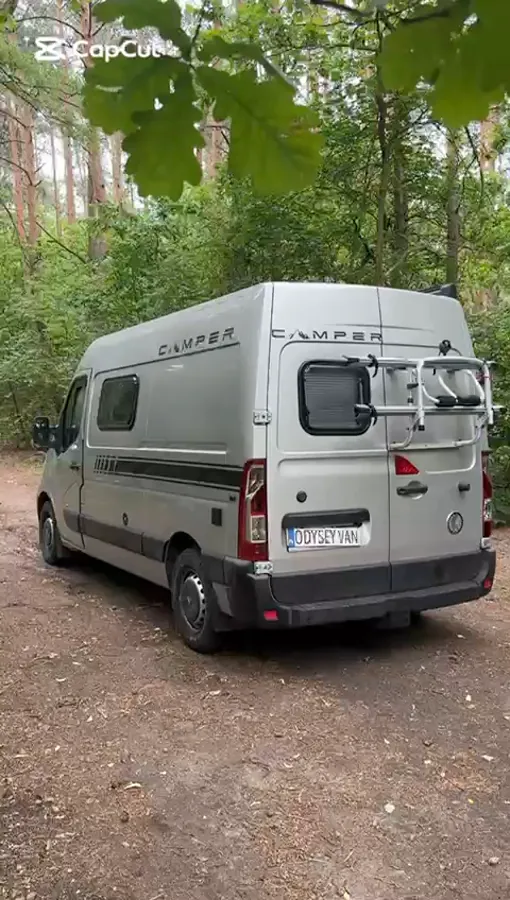 Film: zabudowa z drewnianymi lamelami na suficie, toaletą i rozkładanym stołem